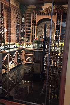 glass door wine cellar with wood framing